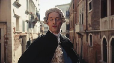 Venedik, İtalya - 05 Mart 2024 Saray Lordu kostümü ve peruk giymiş olgun bir adamın portresi dar bir kanalda duruyor. Aktör asaletini ve onurunu eski kasaba sokaklarında gösteriyor. Karnaval etkinliği