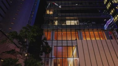 Hong Kong şehir merkezinde akşam lobisi aydınlanmış iş merkezi düşük açılı çekim. Meşgul Asyalı megapolis 'in ticari şehir mimarisi. Şirket Merkezi