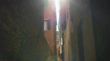 Venedik bölgesinde kurumuş çamaşırları olan eski binalar arasında dar bir yol. Kasaba bloğundaki ortaçağ mimari simgelerini gözlemliyorum. Antik cadde ve konut evleri