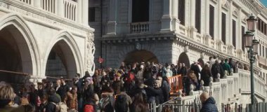 VENICE, İtalya - 05 Mart 2025: Sokak festivalinde Doge Palace yakınlarındaki yaya köprüsü boyunca büyük bir turist kalabalığı yürüyor. Halk, Cumhuriyet hükümetinin eski bir konutunu gözlemliyor. Anamorfik lens
