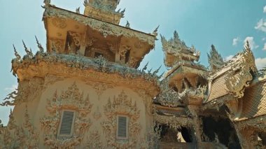 CHIANG RAI, THAILAND - Eylül 04 2025 Ölüm Tapınağı binası altın detaylarla görkemli görünüyor. Süslemeler bilgeliği ve manevi berraklığı sembolize eder. Yapı ışıl ışıl parlıyor.