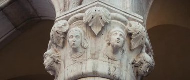 Venedik, İtalya - 05 Mart 2025: açık gökyüzünün altındaki Doge Place 'te oyulmuş insanların başlarıyla mermer sütun başkenti. Venedik 'teki Saint Mark Meydanı' nda Rönesans mimarisinin başyapıtı