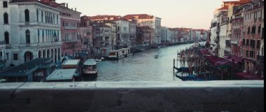 Venedik, İtalya - 05: 2025 Venedik şehrinin ünlü Grand Canal kıyılarına demirlemiş nehir tramvayları ve gondolları alacakaranlıkta. Eski İtalyan kasabasında geleneksel turist su araçları