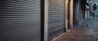 Venedik 'teki boş asfalt sokakta metal parçalarıyla kaplı küçük vitrinler. Akşamları eski İtalyan şehrinin tarihi bölgesindeki yerel dükkanları kapatırdı. Anamorfik lens