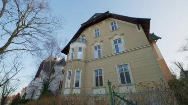 Pencereleri olan eski moda bir bina ve mavi gökyüzünün altında alçak açılı çekim yapan sarı cephe. Spring City caddesinde eski konutlar. Mimari