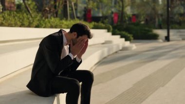 Genç İspanyol iş adamının portresi, parktaki korkuluklara otururken elleri üzerine düşüyor. Kırık Latin menajer işini ve şehir merkezindeki iş krizinin mali güvenliğini kaybetti