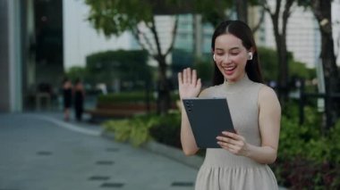 Pozitif Asyalı bir kadının portresi şehir merkezindeki bir binaya bağlanıyor. Genç Koreli kadın, dijital tabletle dijital ortamda arkadaşını karşıladı