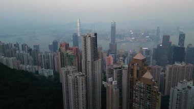 Liman açılırken, Ridge ön planda kalabalık gökdelenler var. Huzurlu Hong Kong şehrinden geçen feribotlar çizgiler çizerken ICC binası su üzerinde duruyor.