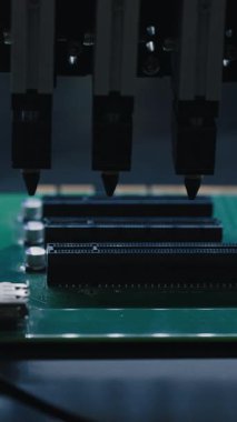 Tahtaya robotik kol yerleştirme bileşenlerini içeren bir devre kartı montaj sürecinin yakın görüntüsü, karmaşık detaylar ve hassasiyet sergiliyor. Dikey çekim