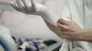 Doktor hastanede eldiven ile giyiyor