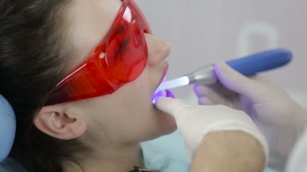 Paciente do sexo feminino recebendo tratamento com equipamento de luz UV dental — Vídeo de Stock