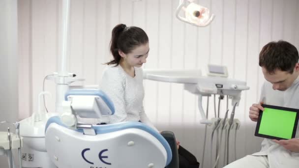 Dentista explicando procedimiento a paciente femenina en consultorio de dentista — Vídeo de stock