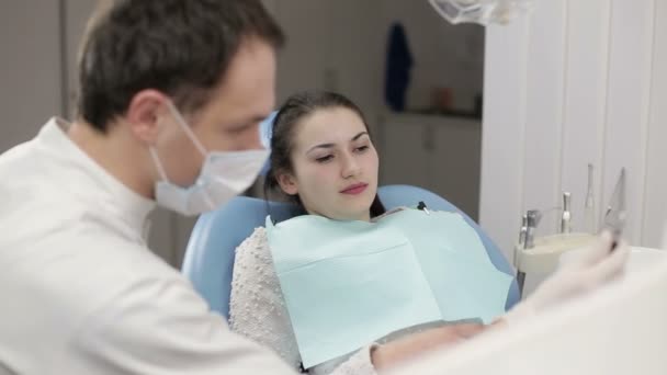 Dentista muestra un paciente de rayos X en la tableta — Vídeos de Stock