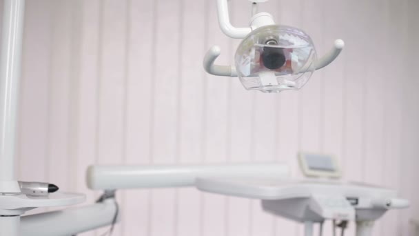 Dental light stand next to dental chair and tools in use for dentist.