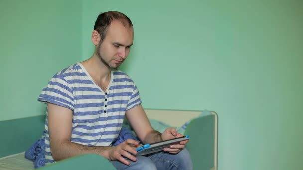 Hombre joven usando tableta en casa — Vídeos de Stock