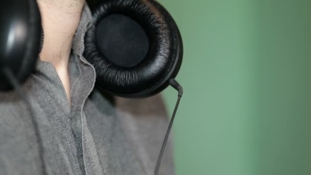 Close up headphones around the neck of a young man — Stock Video