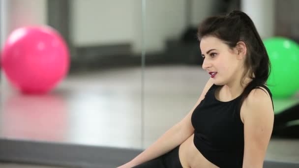 Красивая спортивная девушка расслабляется после тренировки в фитнес-центре — стоковое видео