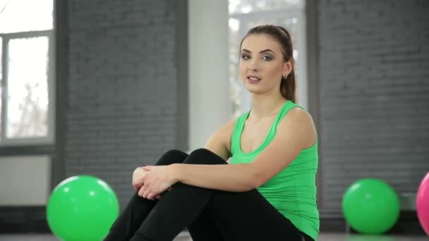 Усміхнена молода жінка розслабляється після тренування — стокове відео