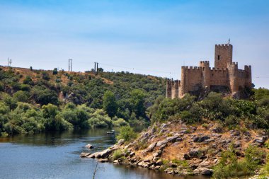 Almourol 'un Kalesi (Castelo de Almorol) kalenin solundaki Tejo nehri ile, Praia do Ribatejo, Portekiz. Kaleli renkli bir ortam.
