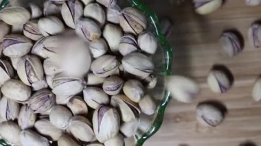 Fıstıklar yeşil bir cam kaseye düşüyorlar..