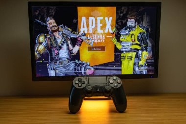 Lizbon, Portekiz- 8 Şubat 2020: EA Games 'ten APEX Efsaneleri oynayan 4 PlayStation denetleyici (turuncu renkle ışıklandırılmış). Sezon 8. Battle Royale oyunu oynamak için özgür.