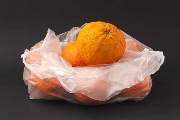 Orangen in einem weißen Umschlag auf schwarzem Hintergrund — Stockfoto