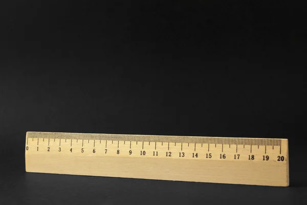 Holzlineal isoliert auf schwarzem Hintergrund — Stockfoto
