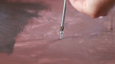 İşçi tahtada vida çeviriyor.