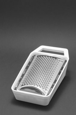 Grater with white plastic lining on a black background