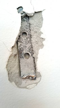 Yapısal hasarı sembolize eden ve tamir kavramını sembolize eden demiri ile duvar çatlağı yakın plan görüntüsü.