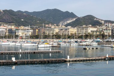 Salerno, campania, İtalya, 15 Mart 2026: Salerno, İtalya yat limanı iskeleyi yelkenliler, şehir binaları ve dağlarla dolduruyor.