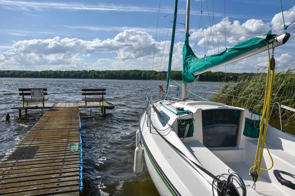 停泊在绿河芦苇湖码头或码头上的白色马达或帆船 — 图库照片