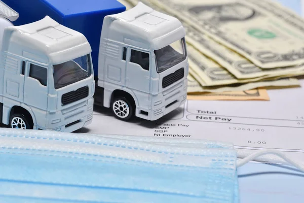 一种卡车玩具 上面有美元钞票和面罩 在概念上是关于运输的 以防止考拉病毒大流行 — 图库照片