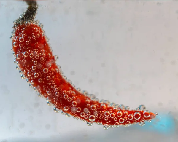 Mineralwasser Gehaengt 'teki Eine Frucht Wird. Es Entstehen viele Blasen auf und neben der Frucht.