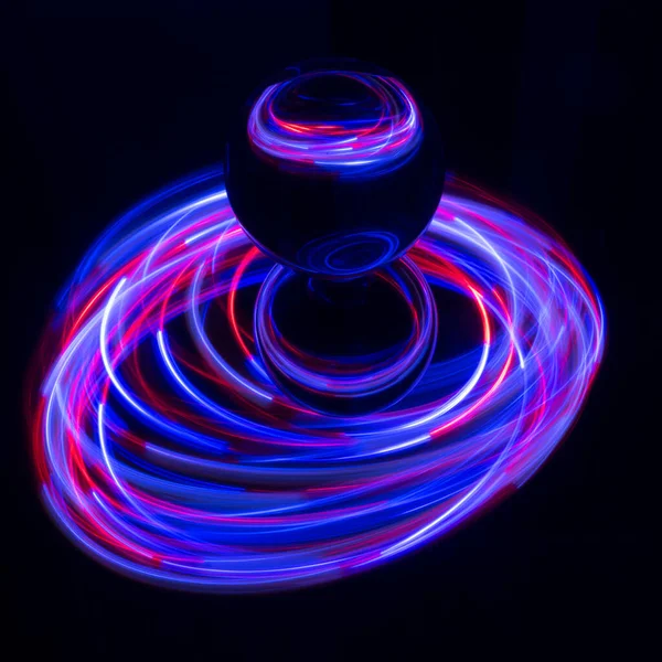 Painting with light on a mirror with small colored lamps and a glass ball.