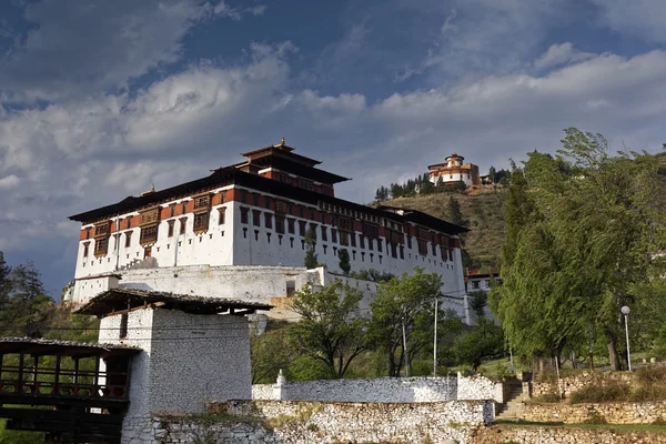 Paro Rinpung Dzong, un monasterio budista y fortaleza de pie en una colina sobre un río Paro Chu cerca de la ciudad Paro, PARO, BHUTAN, MAYO 2015 — Foto de Stock