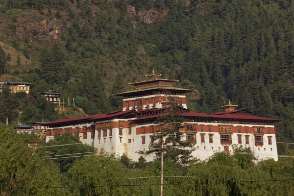 Paro Rinpung Dzong, un monasterio budista y fortaleza de pie en una colina sobre un río Paro Chu cerca de la ciudad Paro, PARO, BHUTAN, MAYO 2015 — Foto de Stock