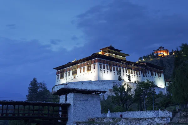 Paro Rinpung Dzong, un monasterio budista y fortaleza de pie en una colina sobre un río Paro Chu cerca de la ciudad Paro, PARO, BHUTAN, MAYO 2015 — Foto de Stock