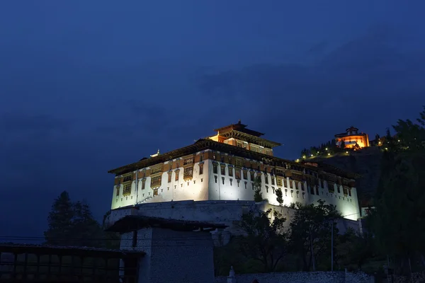 Paro Rinpung Dzong, un monasterio budista y fortaleza de pie en una colina sobre un río Paro Chu cerca de la ciudad Paro, PARO, BHUTAN, MAYO 2015 — Foto de Stock