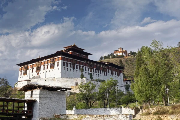 Paro Rinpung Dzong, un monasterio budista y fortaleza de pie en una colina sobre un río Paro Chu cerca de la ciudad Paro, PARO, BHUTAN, MAYO 2015 — Foto de Stock