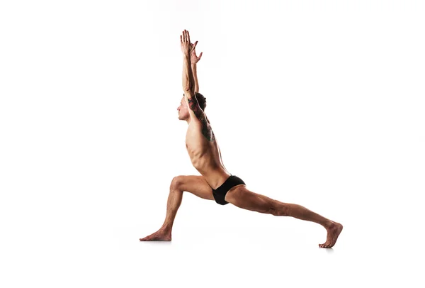 Homem está envolvido em ginástica, ioga e fitness, fundo branco — Fotografia de Stock