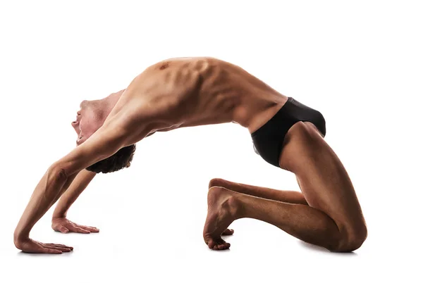 Joven hombre fuerte haciendo yoga y gimnasia, puente —  Fotos de Stock