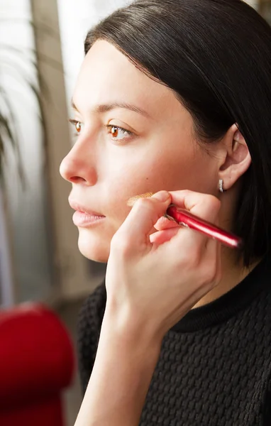 Beautiful young brunette woman doing makeup — Stock Photo, Image