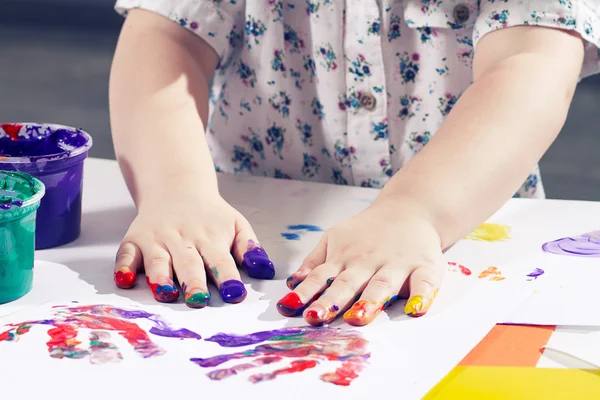 Bela menina desenha um dedo tintas — Fotografia de Stock