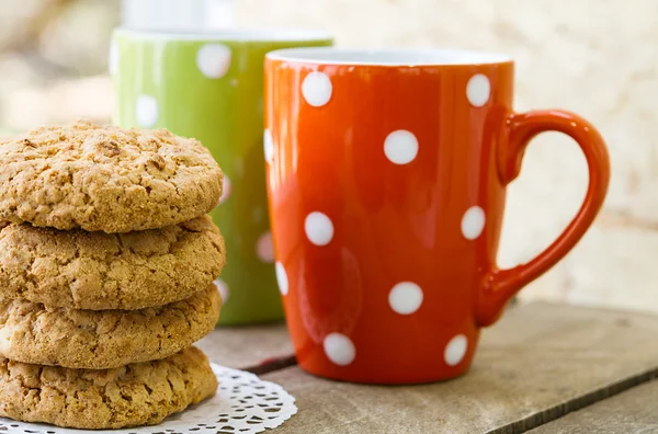 Homemade cookies on the table, colored tea cups — Stock Photo, Image