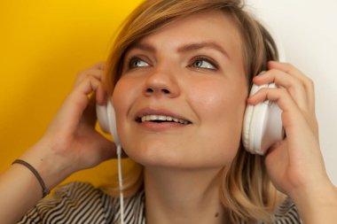 Büyük beyaz kulaklıklı genç güzel kız, kulaklıkla dinle.