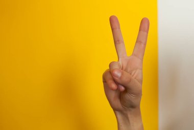 El hareketi, zafer işareti sarı arka plandaki parmaklar.