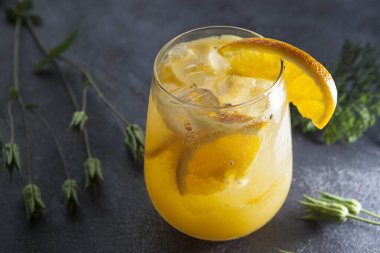 Serinletici portakallı limonata sisli bir bardakta buzlu, yaz ferahlatıcı bir içecek.