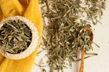 Toplamak için kuru şifalı otlar, bitkisel ilaçlar, bitkisel ilaçlar, beyaz bir masa üzerindeki deniz dikenli yapraklar.