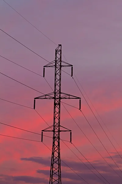 De lijn van de transmissie van de macht en een gouden zonsondergang — Stockfoto
